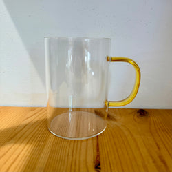 Glass cup with yellow glass handler