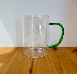 Glass cup with green glass handler